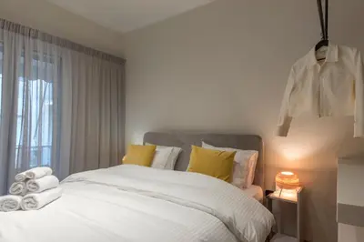 a bedroom with a white bed with yellow pillows at Modern Ilisian Apartment in Athens