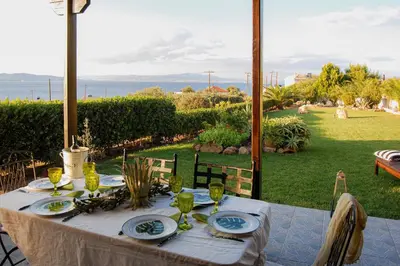 a table with plates and wine glasses on a patio at Villieta Marina in Vaia