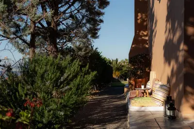 a porch with a bench and some bushes and trees at Villieta Marina in Vaia