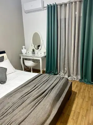 a bedroom with a bed with green curtains and a desk at Miromar in Athens