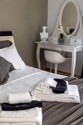 a bed with towels and a table with a mirror at Miromar in Athens