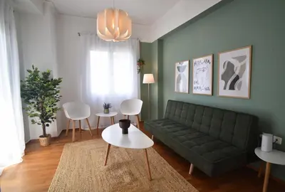a living room with a green couch and white chairs at Ifigenias Apartment-Near Acropolis-Koukaki in Athens