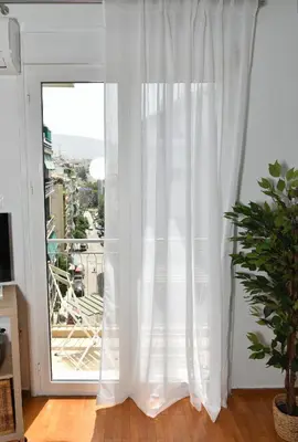 a white curtain in a room with a window at Ifigenias Apartment-Near Acropolis-Koukaki in Athens