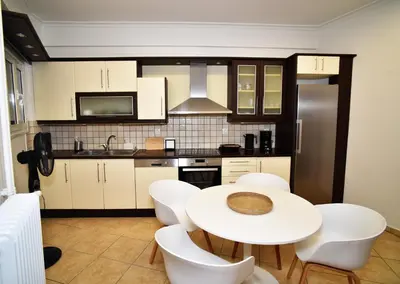 a kitchen with a white table and white chairs at Ifigenias Apartment-Near Acropolis-Koukaki in Athens