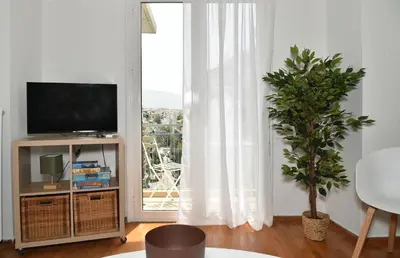 a living room with a tv and a large window at Ifigenias Apartment-Near Acropolis-Koukaki in Athens