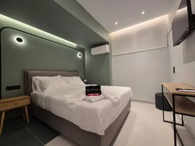 a bedroom with a bed with a green wall at By The Stadium in Athens