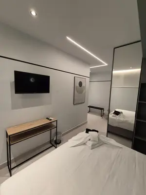a bedroom with a bed and a tv on the wall at By The Stadium in Athens