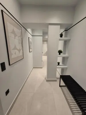 a hallway with white walls and a painting on the wall at By The Stadium in Athens