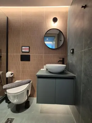 a bathroom with a sink and a toilet and a mirror at By The Stadium in Athens