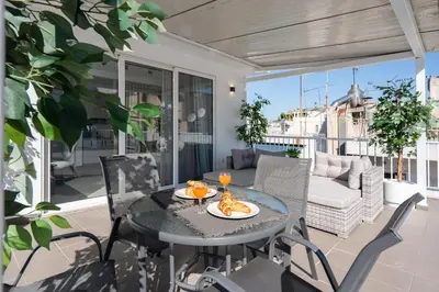 a patio with a table and chairs on a balcony at City View Penthouse with Large Terrace in Athens