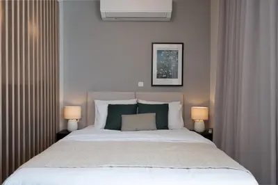 a bedroom with a large bed with two lamps at City View Penthouse with Large Terrace in Athens