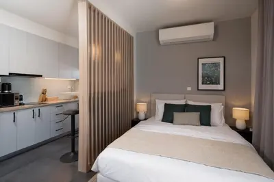 a bedroom with a large bed and a kitchen at City View Penthouse with Large Terrace in Athens