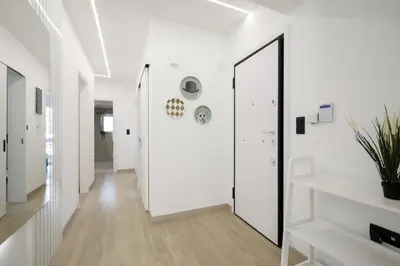 a hallway with white walls and a large mirror at Glyfada Golden Residence - 3 bedroom - Greecing in Athens