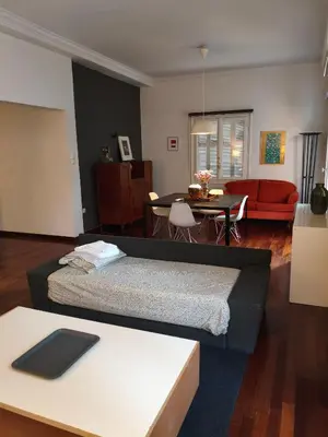 a living room with a bed and a table at Sunny Athens flat near the sea 2 in Athens