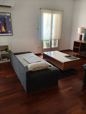 a living room with a bed and a coffee table at Sunny Athens flat near the sea 2 in Athens