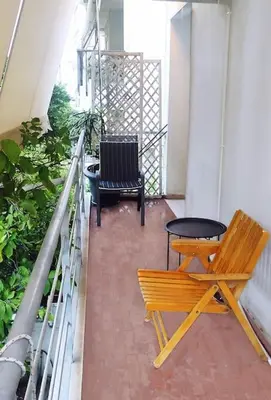 a bench and a chair on a balcony at Sunny Athens flat near the sea 2 in Athens
