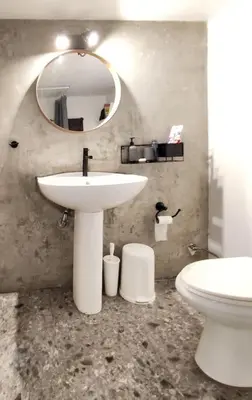 a bathroom with a sink and a toilet and a mirror at Sunny Athens flat near the sea 2 in Athens