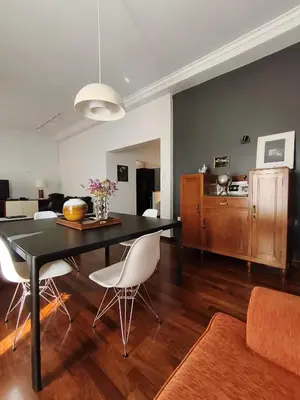a dining room with a black table and white chairs at Sunny Athens flat near the sea 2 in Athens