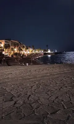 a beach at night with lights on the water at Sunny Athens flat near the sea 2 in Athens