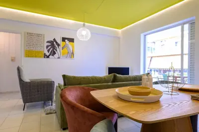 a living room with a green couch and a table at Mesmerizing 2bedroom Luxury in Athens