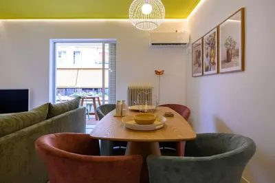 a living room with a table and some chairs at Mesmerizing 2bedroom Luxury in Athens