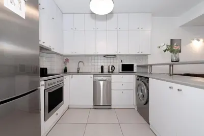 a white kitchen with a sink and a dishwasher at Minimalist 2-Bedroom Apartment with Balcony in the Heart of Athens in Athens