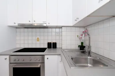 a white kitchen with a sink and a stove at Minimalist 2-Bedroom Apartment with Balcony in the Heart of Athens in Athens
