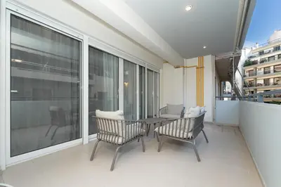 a balcony with a table and chairs and a large window at Minimalist 2-Bedroom Apartment with Balcony in the Heart of Athens in Athens