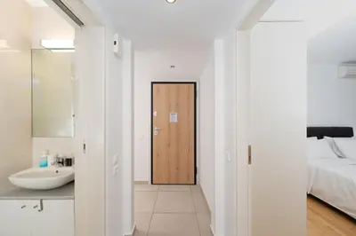 a bathroom with a sink and a door to a bedroom at Minimalist 2-Bedroom Apartment with Balcony in the Heart of Athens in Athens