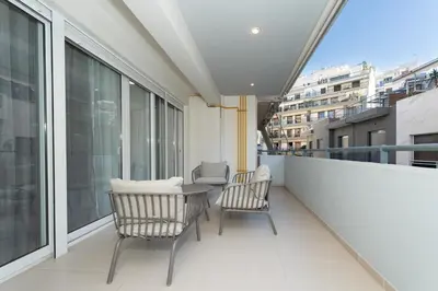 a balcony with two chairs and a table at Minimalist 2-Bedroom Apartment with Balcony in the Heart of Athens in Athens