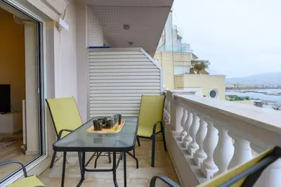 a balcony with a table and chairs on a balcony at Kastella's Amazing Islandic View in Piraeus