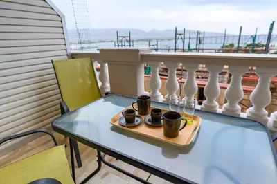 a table with cups on a tray on a balcony at Kastella's Amazing Islandic View in Piraeus