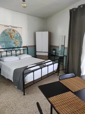 a bedroom with two beds and a table and a map at Υπέροχη θέα in Athens