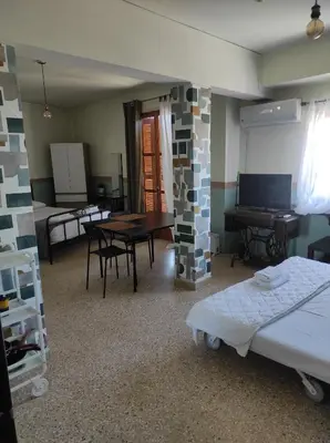 a room with a bed and a table and a dining room at Υπέροχη θέα in Athens