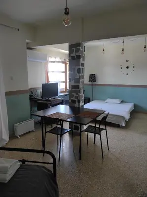 a room with a table and a bed and a desk at Υπέροχη θέα in Athens