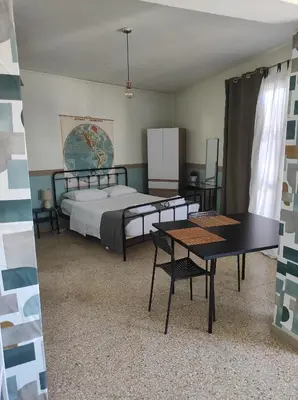 a room with a bed and a table and chairs at Υπέροχη θέα in Athens