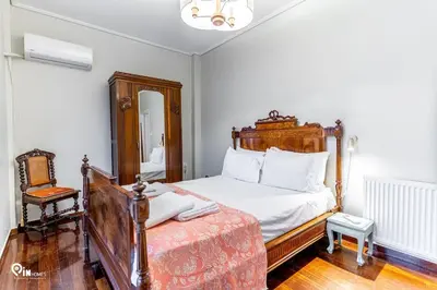 a bedroom with a wooden bed and a chair at Hliana - Premium Sky & Sunset View House in Glyfada in Athens