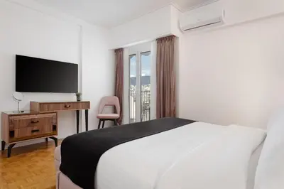 a hotel room with a bed and a television at Athens Golden Light Premium Residence in Athens