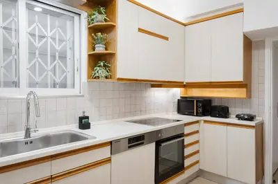 a kitchen with white cabinets and a sink at Athens Golden Light Premium Residence in Athens