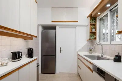 a white kitchen with a refrigerator and a sink at Athens Golden Light Premium Residence in Athens
