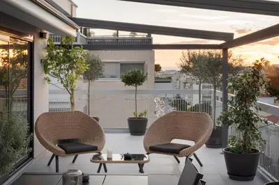 two chairs and a table on a balcony with plants at Athens Golden Light Premium Residence in Athens