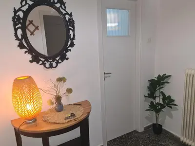 a table with a lamp and a mirror on a wall at Galatsi Studio Apartment -Attica in Athens