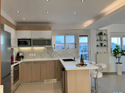 a kitchen with white cabinets and a counter top at Athens Panoramic Penthouse in Athens