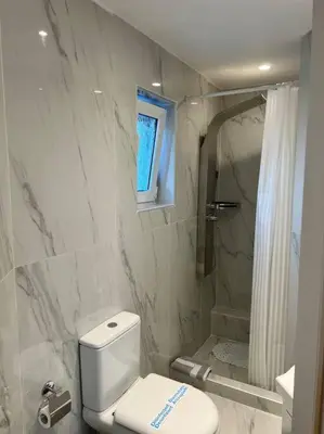 a white bathroom with a toilet and a shower at Athens Panoramic Penthouse in Athens