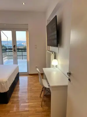a bedroom with a bed and a desk and a bed and a television at Athens Panoramic Penthouse in Athens