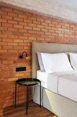 a bed and a table next to a brick wall at Isoyio in Piraeus