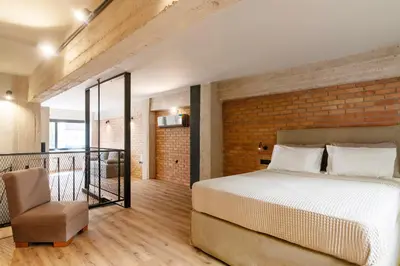 a bedroom with a bed and a brick wall at Isoyio in Piraeus