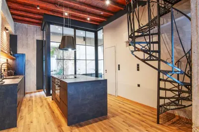 a spiral staircase in a kitchen with a stair case at Isoyio in Piraeus