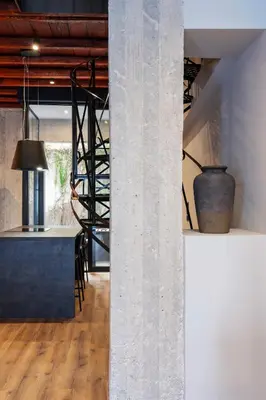 a concrete column in a room with a staircase at Isoyio in Piraeus