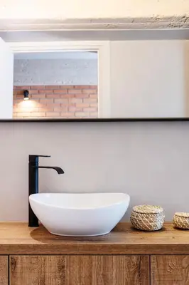 a bathroom with a white sink on a wooden counter at Isoyio in Piraeus